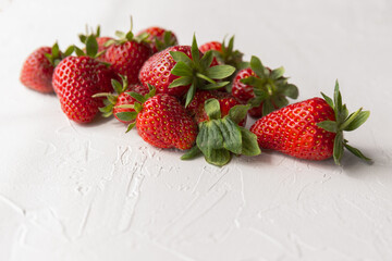 Ripe Red Strawberries with Bright Green Tops on White Textured Background
