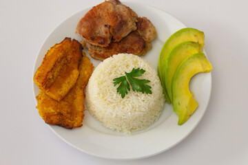 plato almuerzo dominicano, tostones fritos, arroz blanco acompañados de varios aguacates cortados, comida en casa, acercamiento, acercamiento