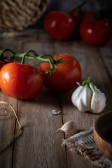 Red tomatoes and garlic on a rustic table
