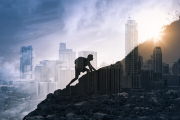 Young man climbing up a mountain overlooking city fighting through obstacles and challenges. Determination, and life goals concept. 