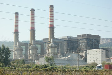 Factory pipes with blue sky in the background. Nuclear power plant. Industrial landscape in modern city. Energy production concept.