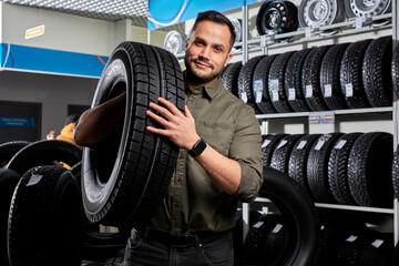 customer tire fitting in the car service, auto mechanic checks the tire and rubber tread for safety, concept: repair of machines, fault diagnosis, repair. man buy in car service shop - obrazy, fototapety, plakaty