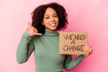 Young african american mixed race woman holding an inspiring message cardboard showing a mobile phone call gesture with fingers.