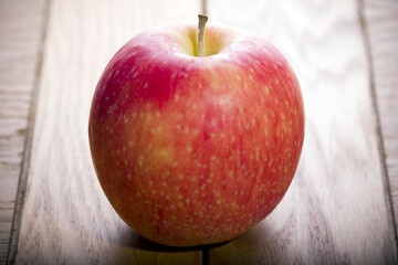 Fresh organic red apple on a wooden countertop