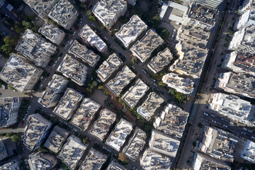 Aerial drone view of the rooftops and the street. Solar panels on the rooftops. Urban cityscape, view from above.