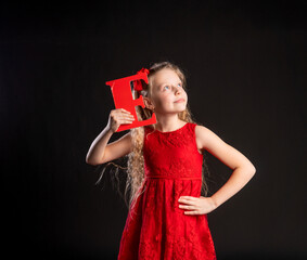 E holds Baby holds in his hand the letter LOVE Valentine Valentine's background, happiness, on the floor of the heart. formula banner. emotion, engagement in a red girl dress, barefoot love symbol