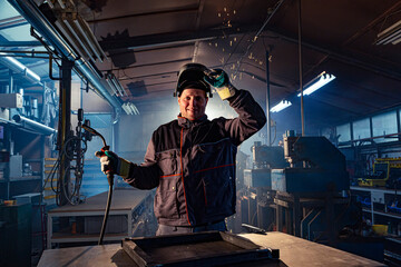 Portrait of a smiling welder posing in the factory