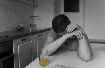 Drunk man with glass of whiskey sleeping on the table.