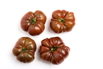 Closeup shot of four black krim tomatoes with textured surface isolated on the white background