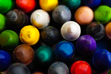 Soft focus closeup macro photo of multicolour old used crayons.