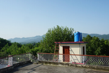 Blue water tank on roof in village.