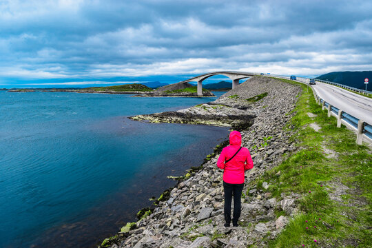 Girl tourist on the background of Storseisundet Bridge (Storseisundbrua). Atlantic Ocean Road. Norway.