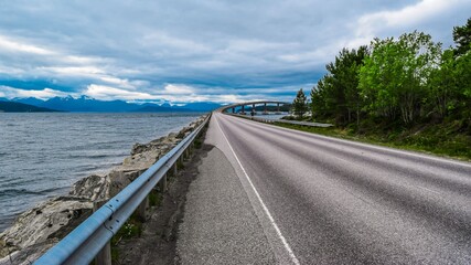 Fototapeta na wymiar Road 64 to Bolsoy Bridge or Bolsoybrua that crosses the Bolsoysund strait between mainland and island of Bolsoya. Norway.