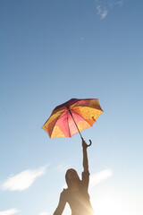 Girl with umbrella in the sunlight, copyspace on the sky