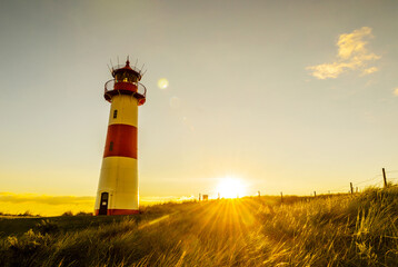 Sunset at the lighthouse List East on a dune of the island Sylt, North Sea, Germany 