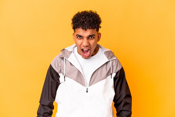 Young african american curly man isolated on purple shouting very angry, rage concept, frustrated.