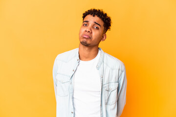 Young african american curly man isolated on purple sad, serious face, feeling miserable and...