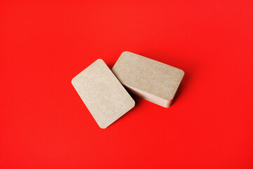 Blank kraft business cards on red paper background. Blank template for branding identity.
