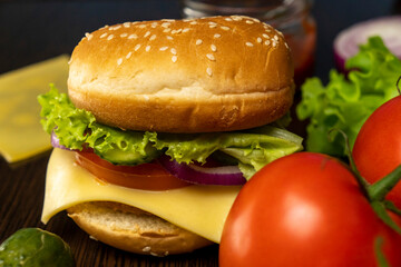 Burger and tomatoes on the table. Making burgers at home. Fast food.