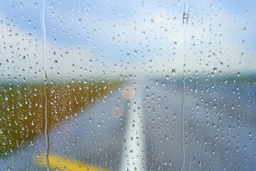 View through the foggy glass of an airplane before takeoff on a rainy day