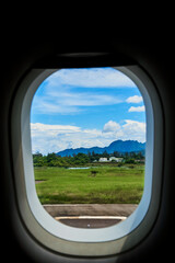View from the window of an airplane on the runway of a tropical island