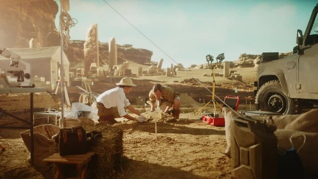 Archaeological Digging Site: Two Great Archeologists Work on Excavation Site, Carefully Cleaning, Lifting Newly Discovered Ancient Civilization Cultural Artifact, Historic Clay Tablet, Fossil Remains