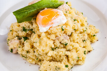 Couscous with chicken and egg on a white plate