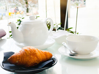  Tea in a white cup with fresh croissant