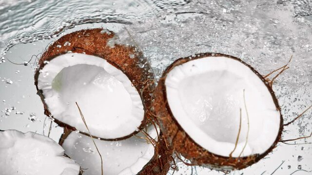 Super Slow Motion Shot of Flying Fresh Coconuts and Water Side Splash at 1000fps.