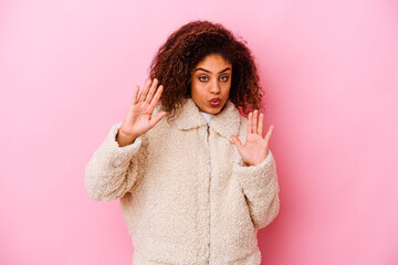 Young african american woman isolated on pink background rejecting someone showing a gesture of disgust.