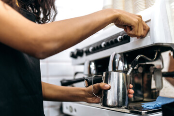 Close up photo of making coffee. Barista girl prepares coffee, pours milk for make a cappuccino using coffee machine