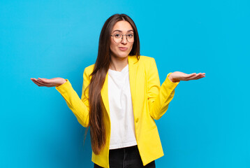 young pretty woman feeling puzzled and confused, doubting, weighting or choosing different options...