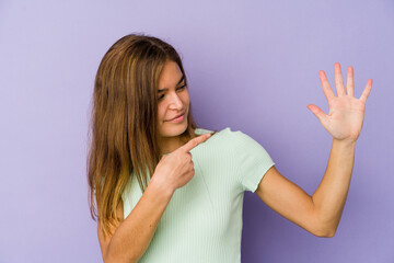 Young skinny caucasian girl teenager on purple background smiling cheerful showing number five with fingers.