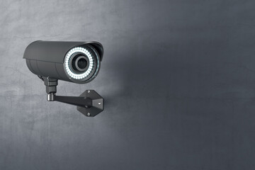 Modern black outdoor security camera on concrete wall