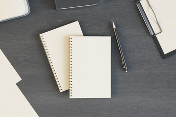 Blank white diaries cover with pen on dark wooden table. Mockup