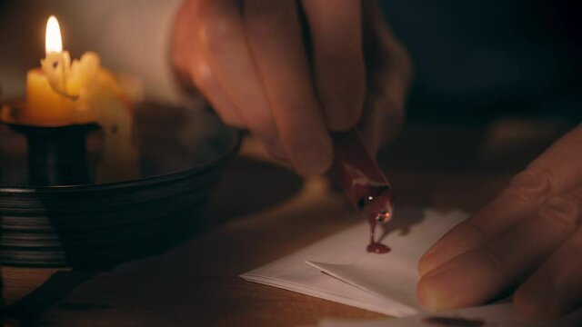Scene of a man from the 18th century lit only by candlelight using sealing paraffin and a wax stamp to secure the letter he has written.