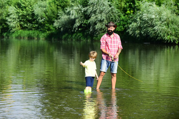 Fathers day. Dad and his child son are fishing on sky background. Fishing became a popular recreational activity.