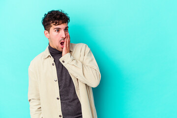 Young caucasian man isolated on blue background being shocked because of something she has seen.