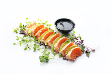 9 piece sushi set. Salmon pieces, avocado and a bowl with a ponzu sauce, isolated on white.