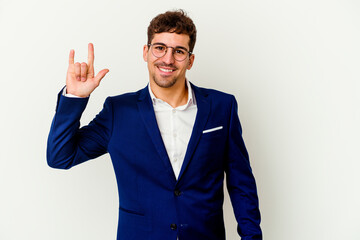 Young business caucasian man isolated on white background showing a horns gesture as a revolution concept.