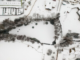Nupaky, Czech republic - February 09, 2021. Aerial view of small frozen pond in winter under the snow