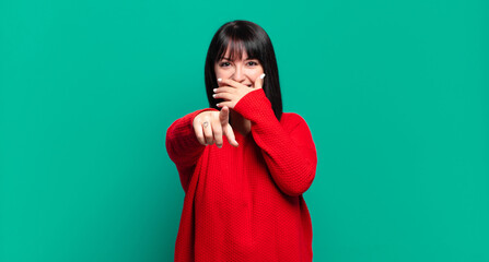 plus size pretty woman laughing at you, pointing to camera and making fun of or mocking you