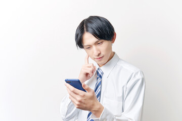 スマートフォンを使うビジネスマン　考える