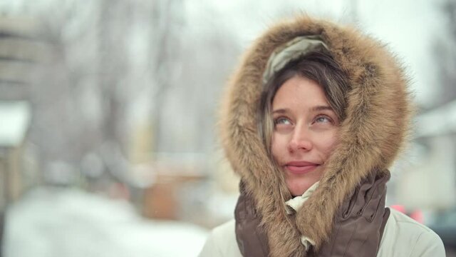 Woman wearing white winter coat posing outside in snow