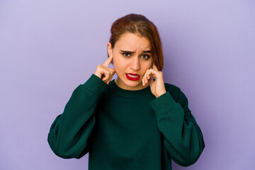 Young arab mixed race woman covering ears with fingers, stressed and desperate by a loudly ambient.