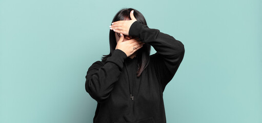 plus size pretty woman covering face with both hands saying no to the camera! refusing pictures or...