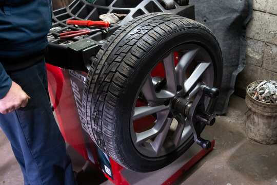 car wheel balancing in tire service garage man rim replace