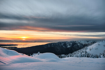 Sunset over sea from mountain top in winter.  View from Mount Seymour peak in North Vancouver. British Columibia. Canada 