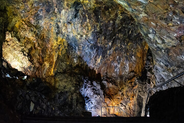 Dark, colorful and lighted interior of the cave of Algar de Carvão, Terceira - Azores PORTUGAL