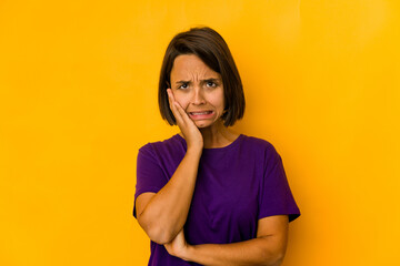 Young hispanic woman isolated on yellow whining and crying disconsolately.